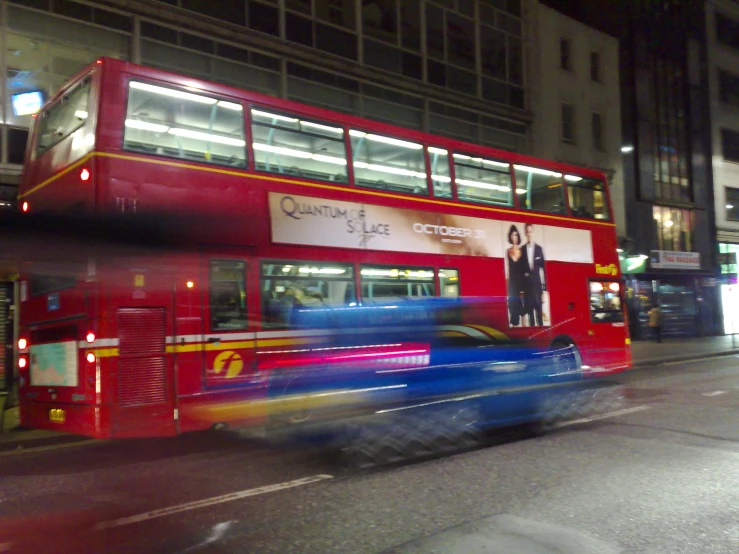 the car is passing under the bus on the street