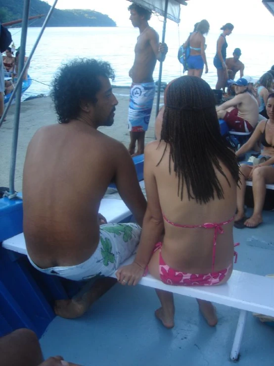 group of people on the back of a boat looking at the water