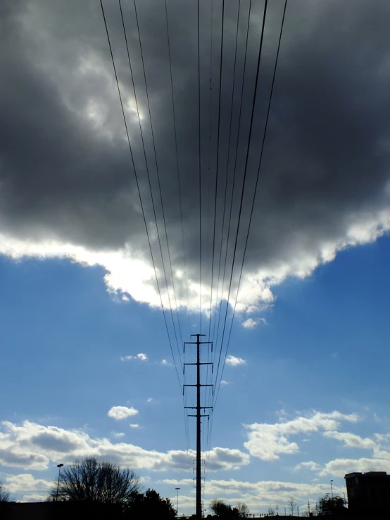 wires against a cloudy blue sky in the countryside