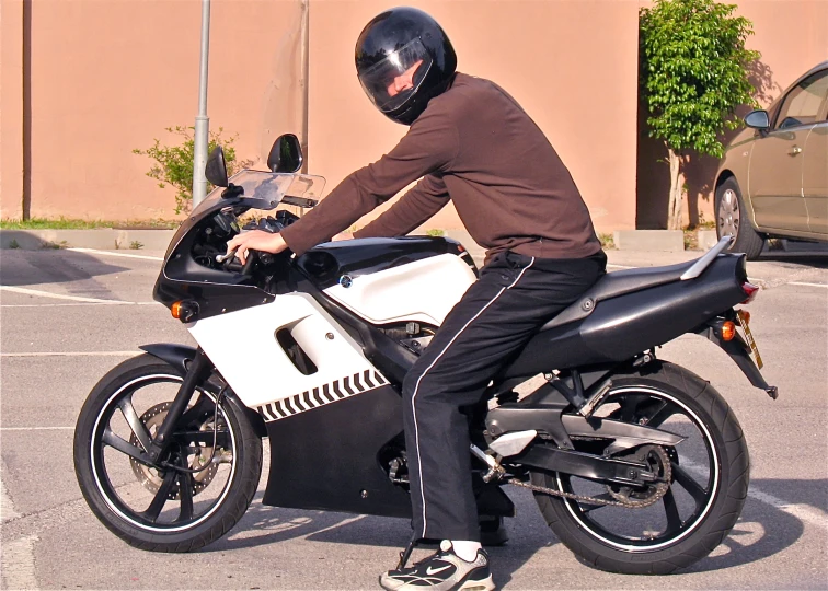 a man in a helmet on a parked motorcycle