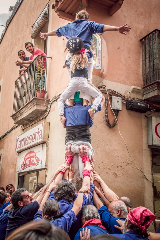 a group of people stacking up one another in a street