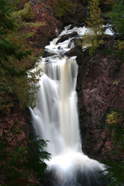 a very tall waterfall surrounded by rocks