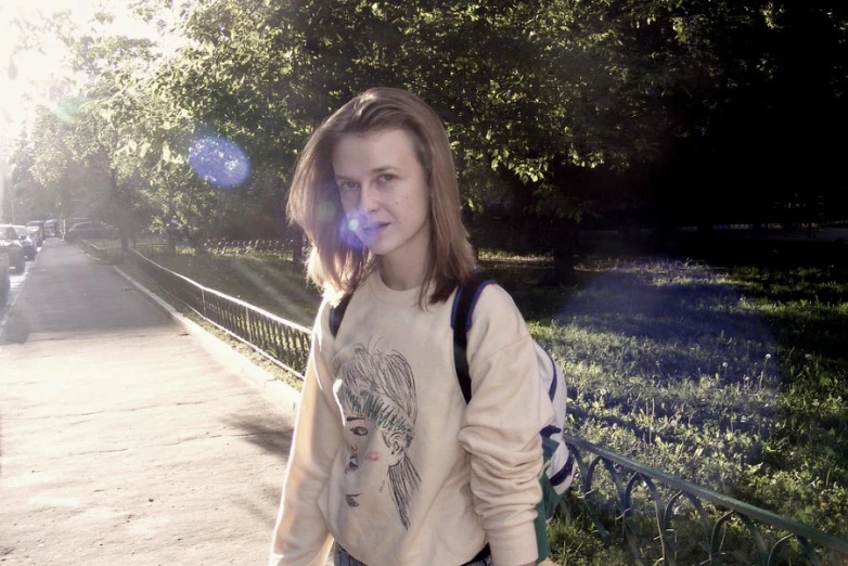 a woman on the sidewalk in front of trees