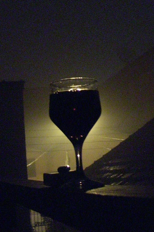 wine glass with light in background in dark room