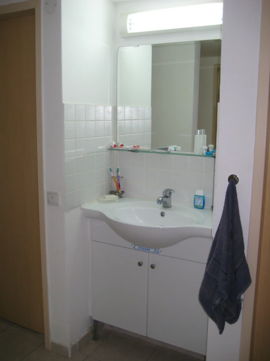 a bathroom is displayed with a mirror, cabinets and towels