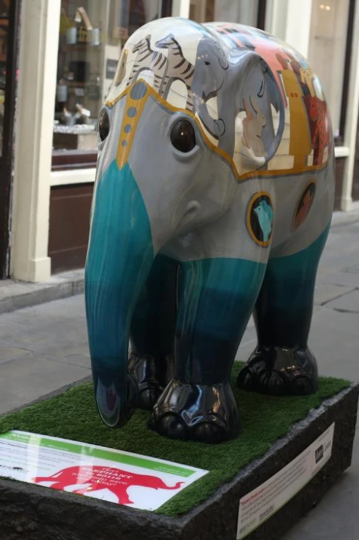 large elephant statue displayed on street with shop windows