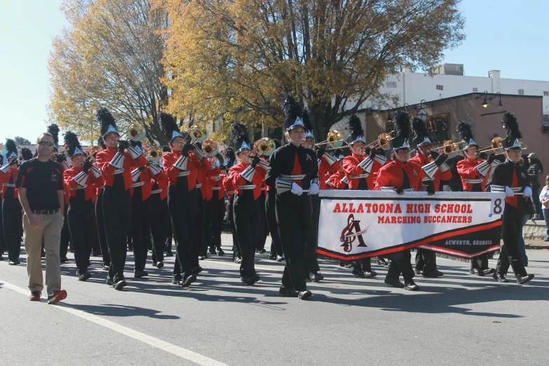 a large marching band is riding down a street