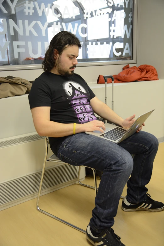 man sitting on a chair with a laptop computer
