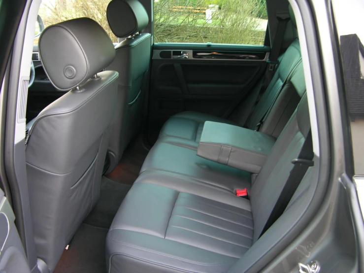the back seats of a grey car are empty