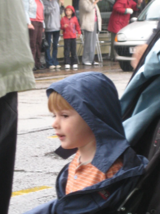 young child sitting on vehicle seat in rain