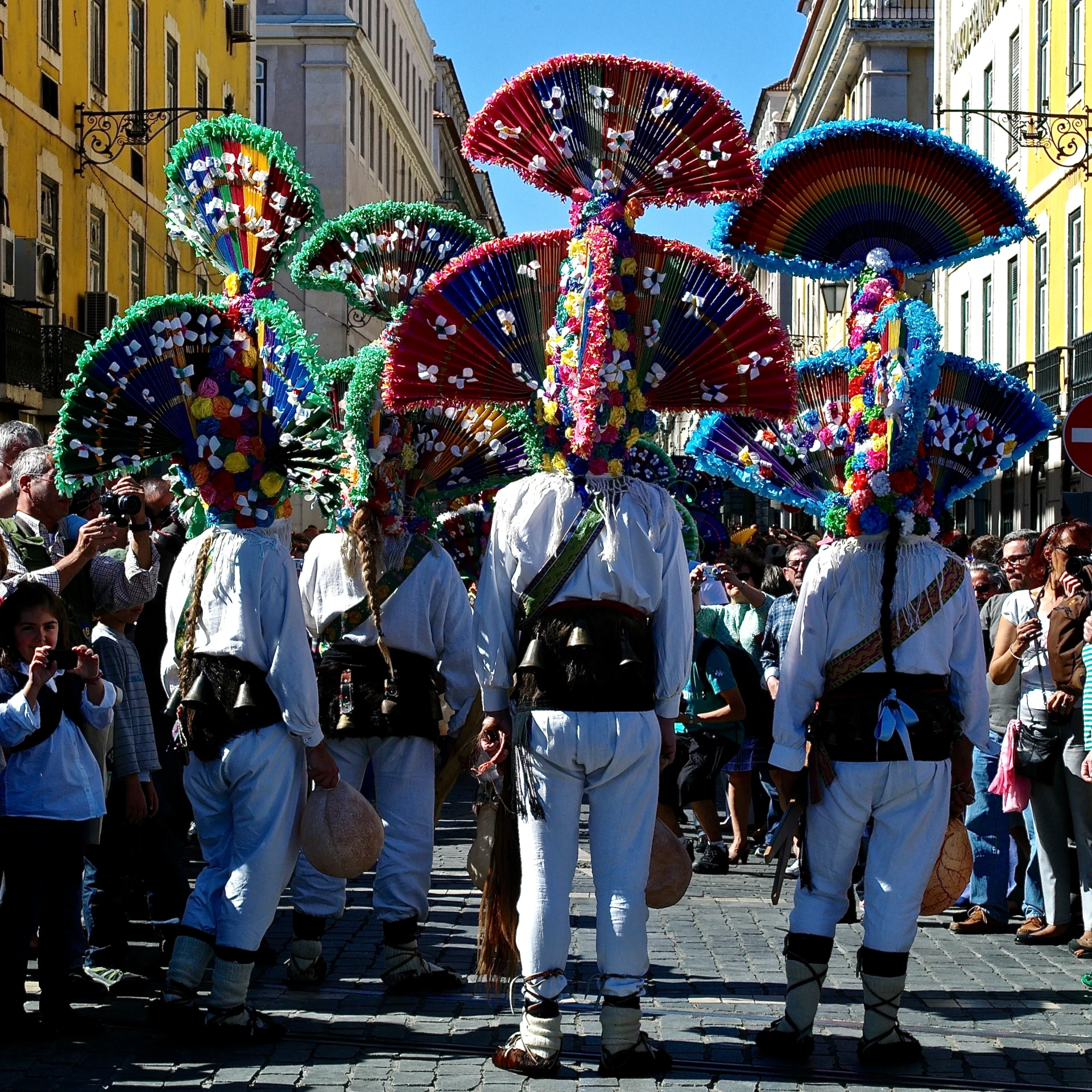 several men are walking down the street decorated with flowers