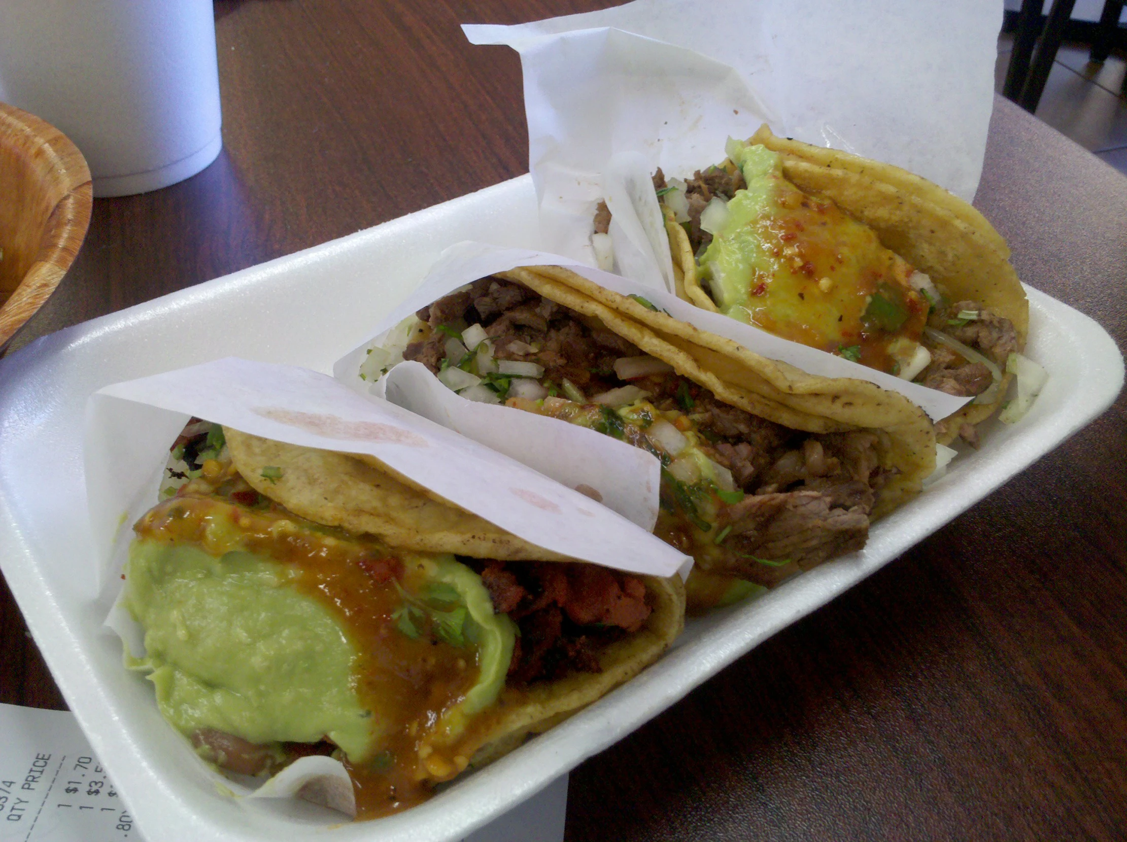 three large beef and avocado tacos are on the tray