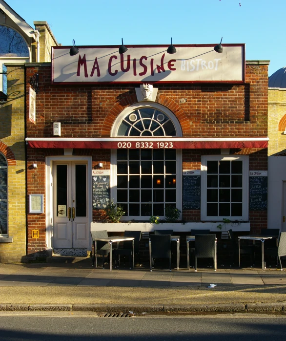 an old fashioned brick restaurant sitting on the side of the road