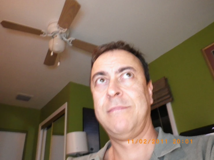 a man with a grey shirt has a ceiling fan
