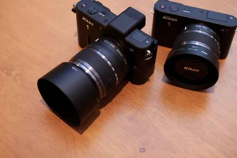 four black cameras and one brown camera on a table