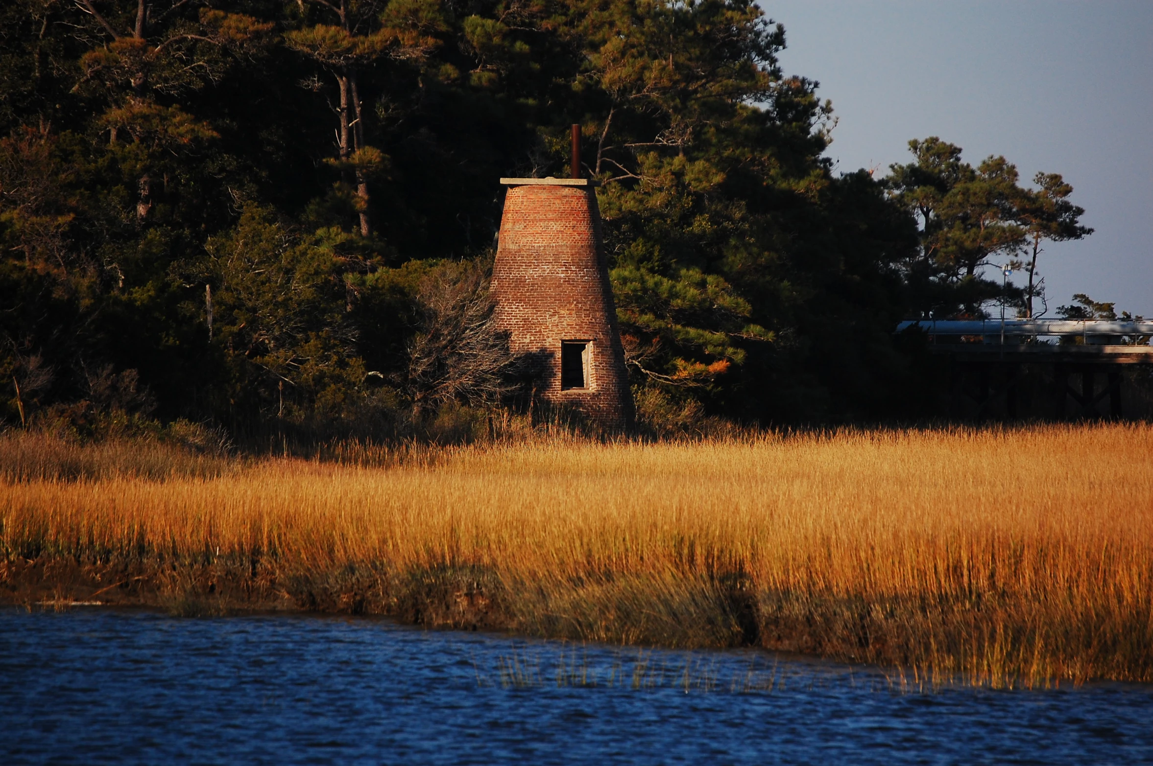 a brick house is surrounded by trees and water