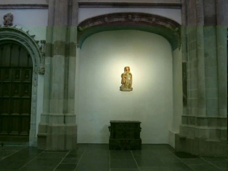 an ornate wall sculpture is suspended from a white light above a chest of drawers