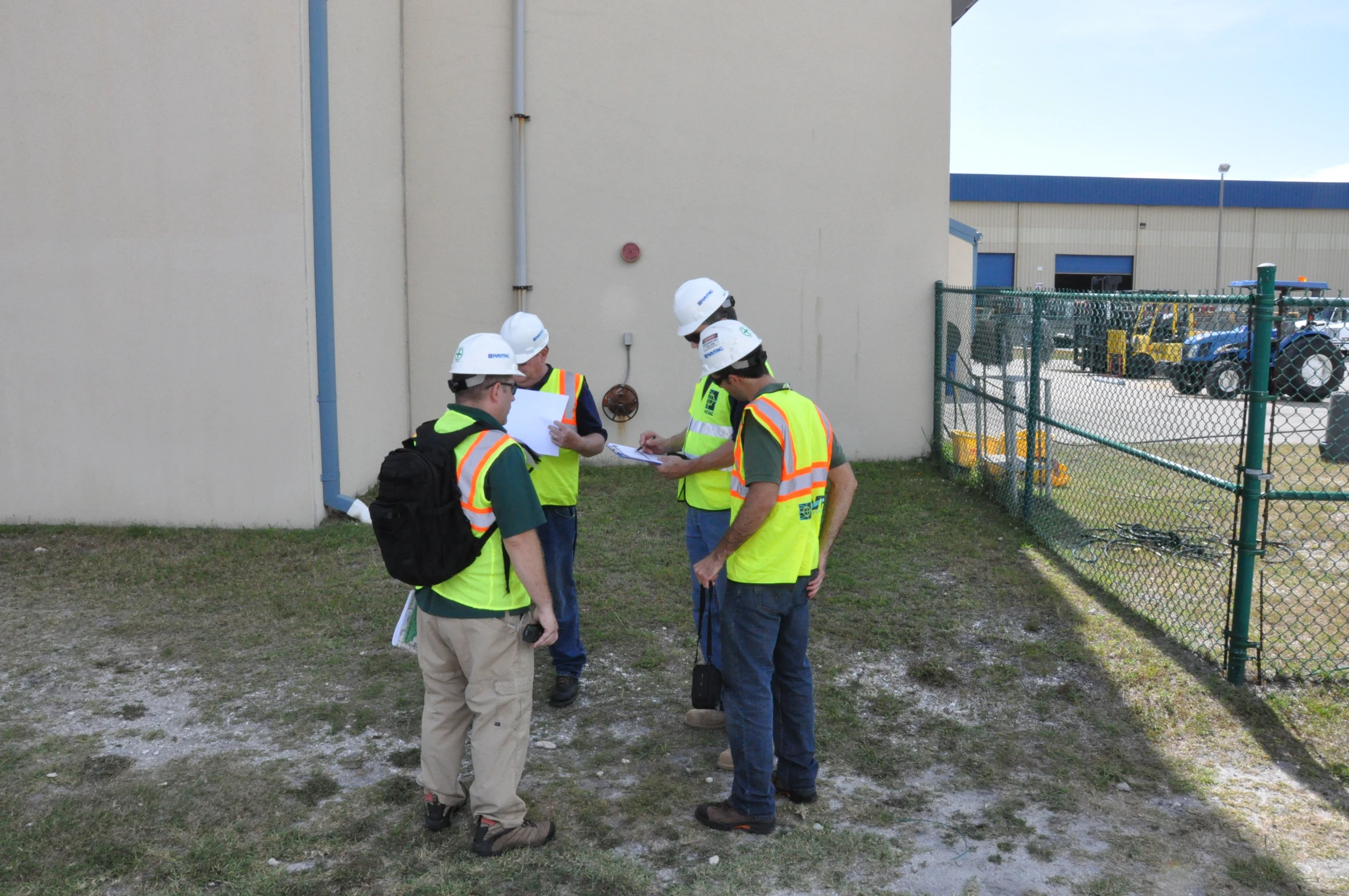 three workers in safety vests checking out soing on the ground