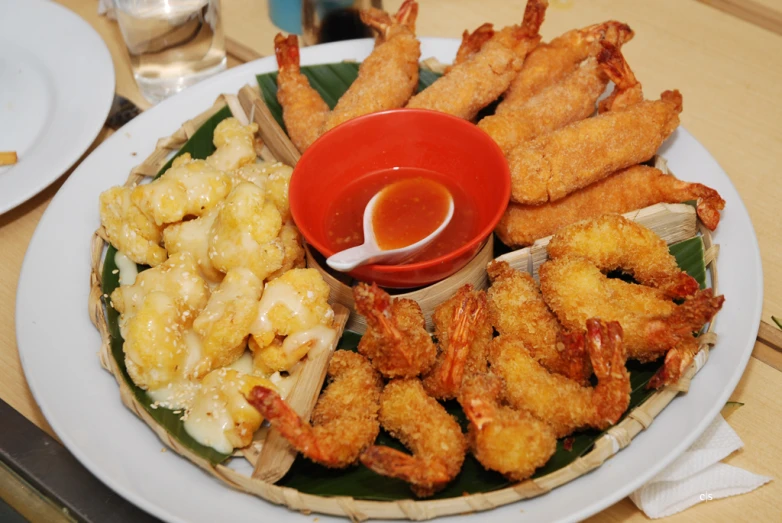 plate of fried shrimp with dipping sauce and side of vegetables