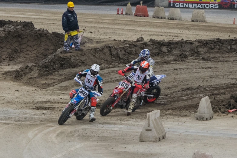 there are two men on dirt bikes riding on a track