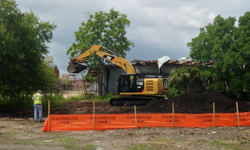 construction on a street corner with a yellow and black bulldozer