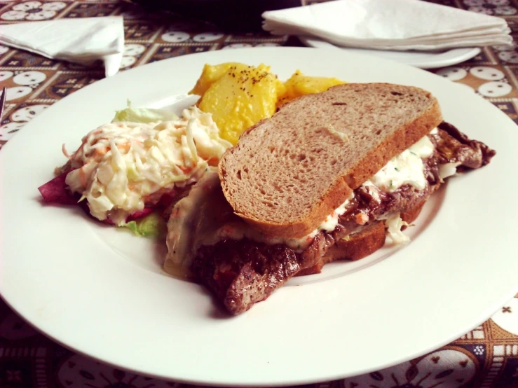 sandwich and salad on plate sitting on table