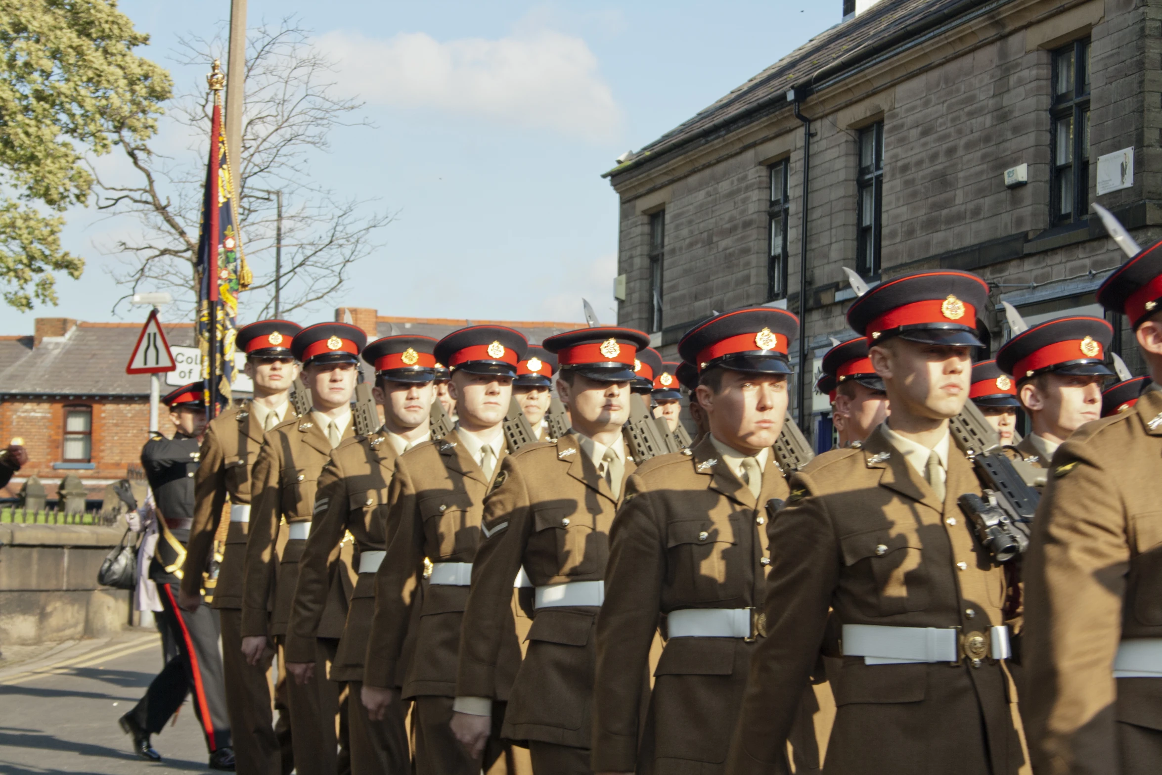 men in brown uniforms marching down the street