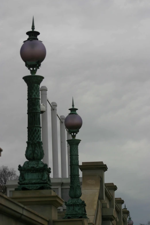 two street lamps sitting in front of pillars