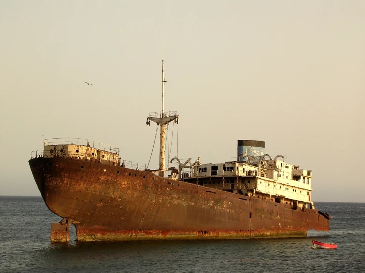 large rusted and rusty ship on the water