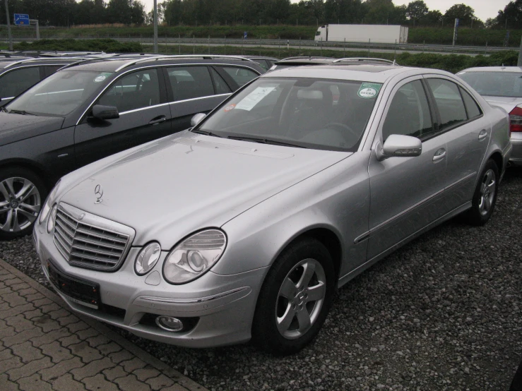 two mercedess are parked side by side in a parking lot