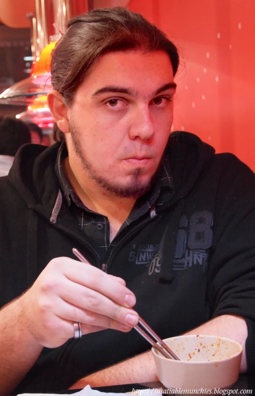 a man sitting in front of a bowl with food