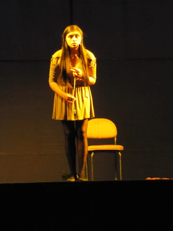 a person standing on a stage with a chair