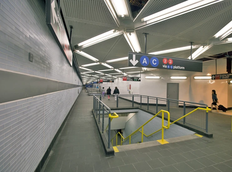 a subway station with stairs and yellow railings