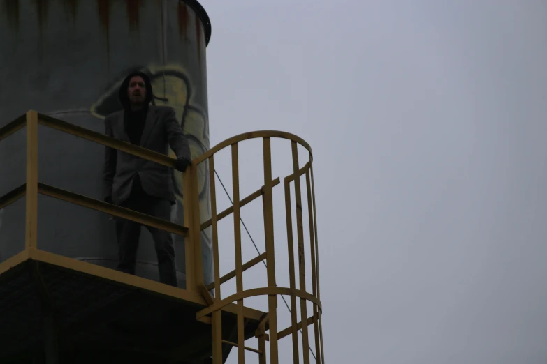 a man in a business suit standing on a tower