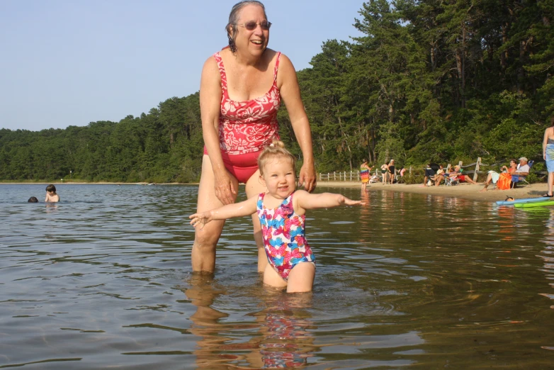 there is a woman and little girl standing in the water