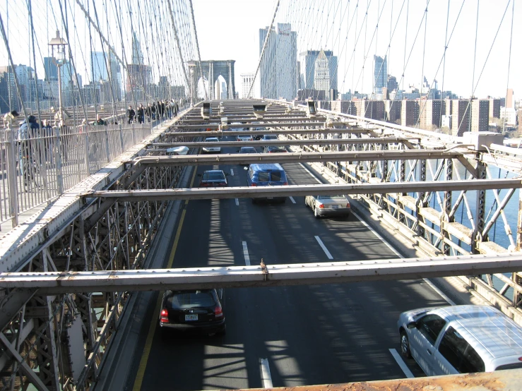 the bridge has vehicles on it and many people