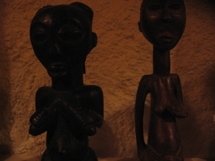 two figurines are lined up on the wall