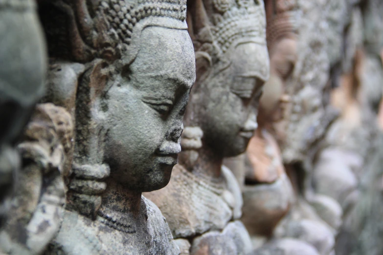 many clay buddha heads on display at a shop