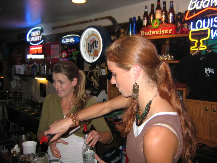 two beautiful young women sitting at a bar together