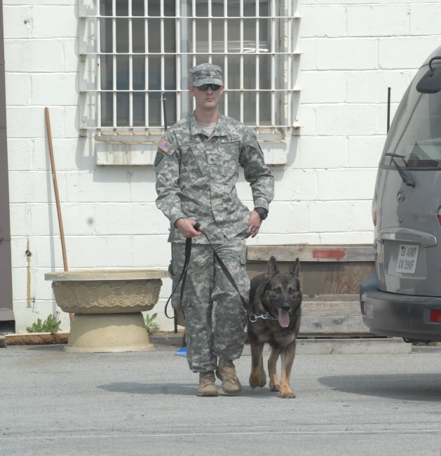 a military man with his german shepard dog