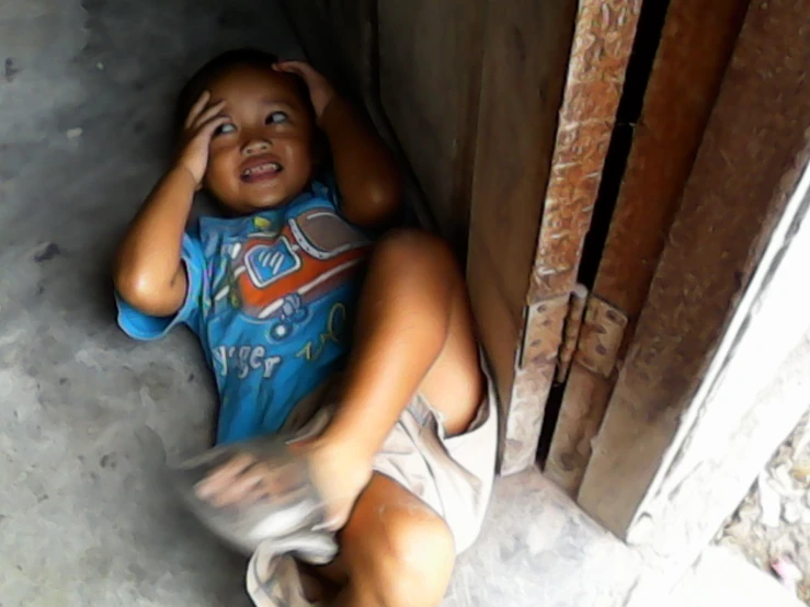 a boy who is sitting down talking on the phone