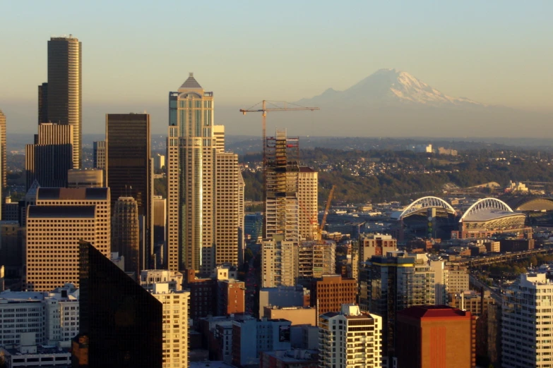 cityscape with tall buildings, an elevated observation building, and mountain in the background