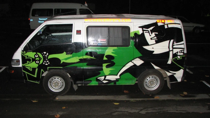 a van is covered with green and white graphics