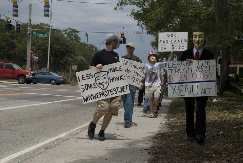 some people walking down the street with signs