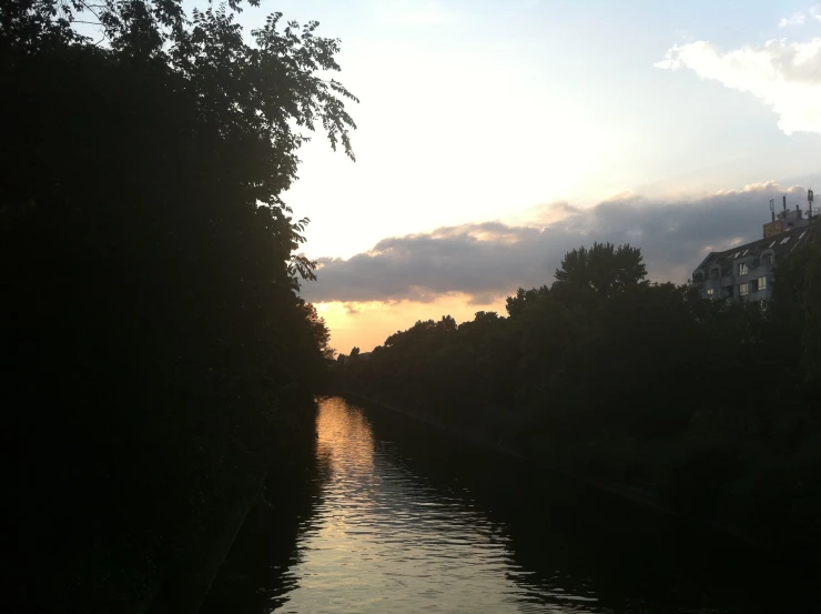 the sun shines brightly over a waterway near some buildings