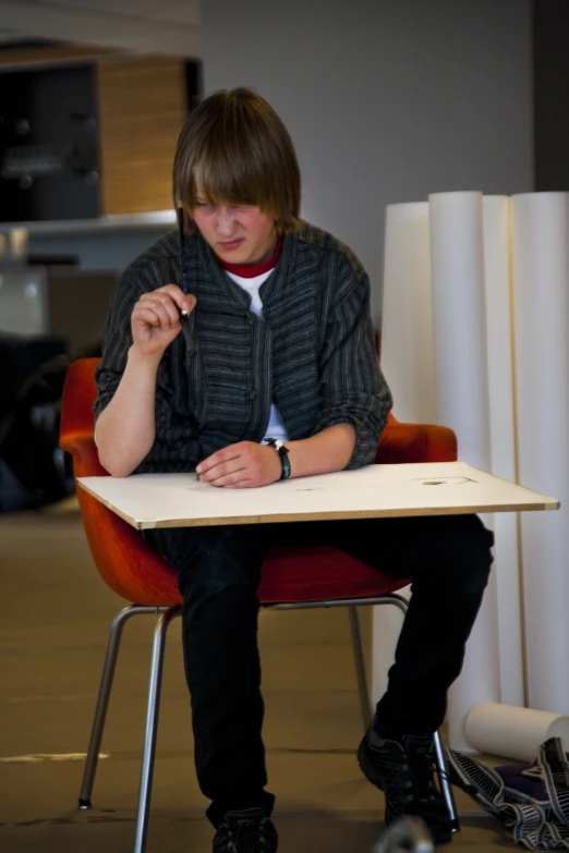 man sitting at desk with pen on hand writing