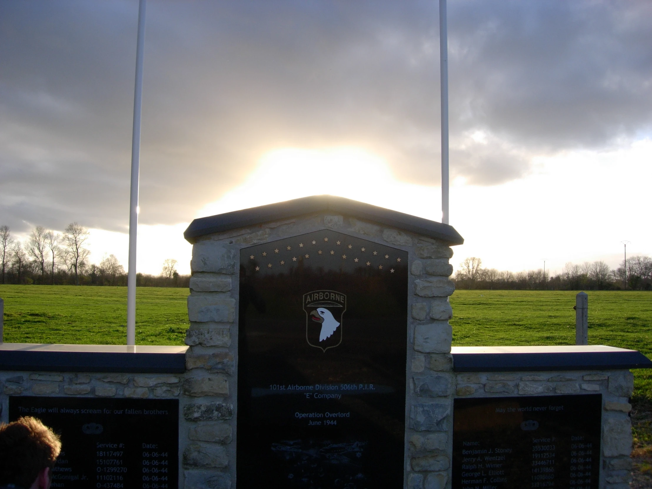 a monument in the middle of a field that has flags