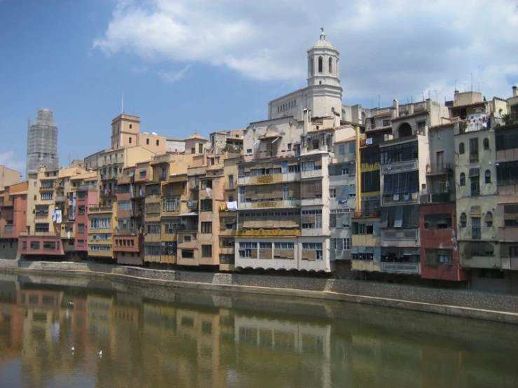 a long row of buildings overlooking water with a bridge