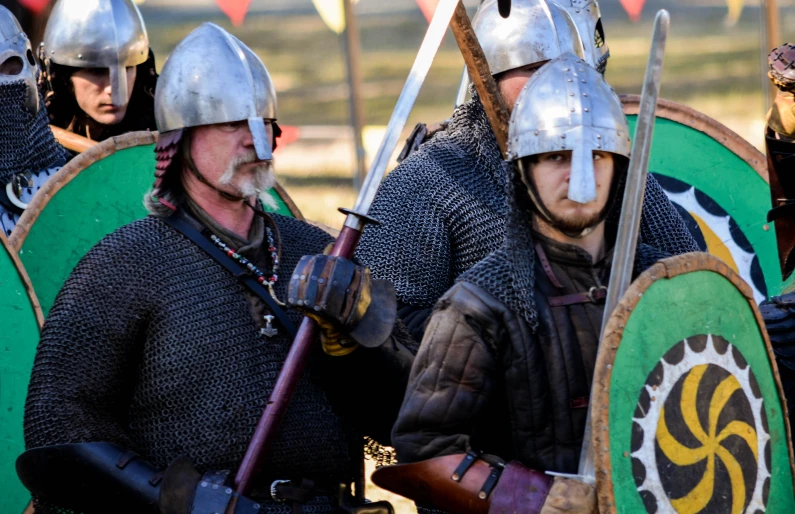 the men in medieval costumes are standing with one another