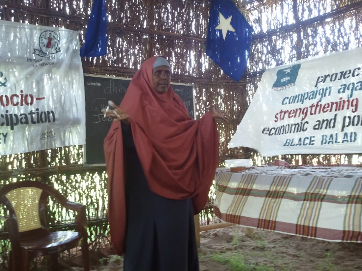 a woman in a red scarf is standing under two signs